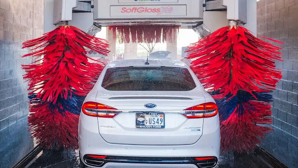 A car going through an automated car wash that relies on APG’s high-quality automated car wash equipment