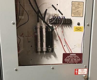 Two desiccant cartridges installed in a control cabinet with glass door