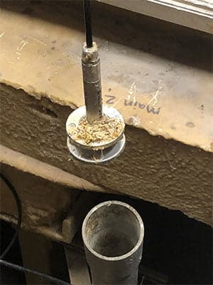 An APG PT-500 with protective cage is covered in sewage