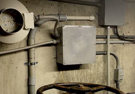 An unlabeled control box with no displays in an underground vault