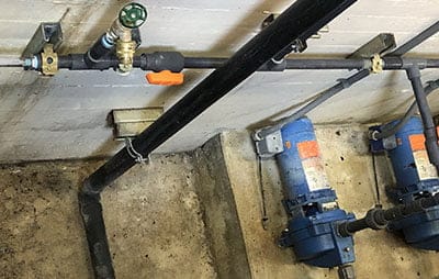 An APG PT-L1 pressure transmitter monitors the pressure downstream of two small pumps
